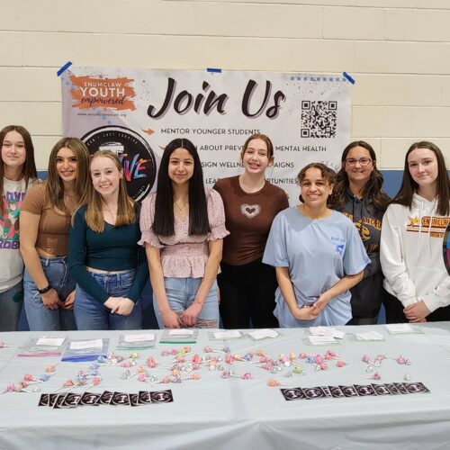 Photo of Thrive club students at an event in front of a table
